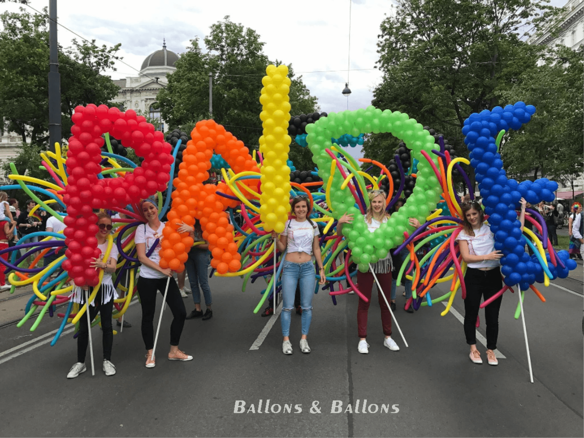 Menschen mit bunten Ballons auf einer Straße in Wien