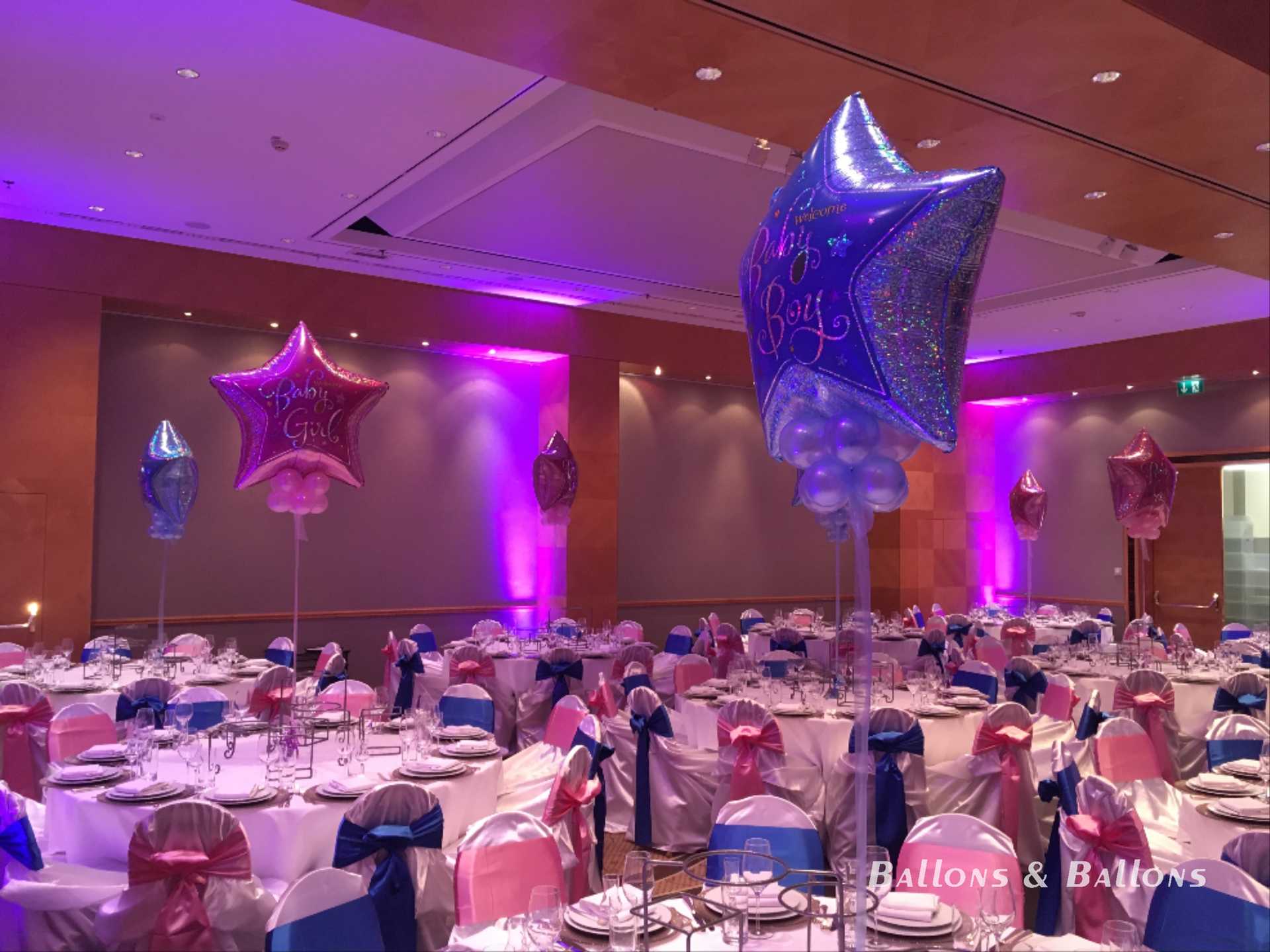 Ein mit Ballons dekoriertes Bankettzimmer mit rosa, blauen, silbernen und weißen Tischdecken in Wien.