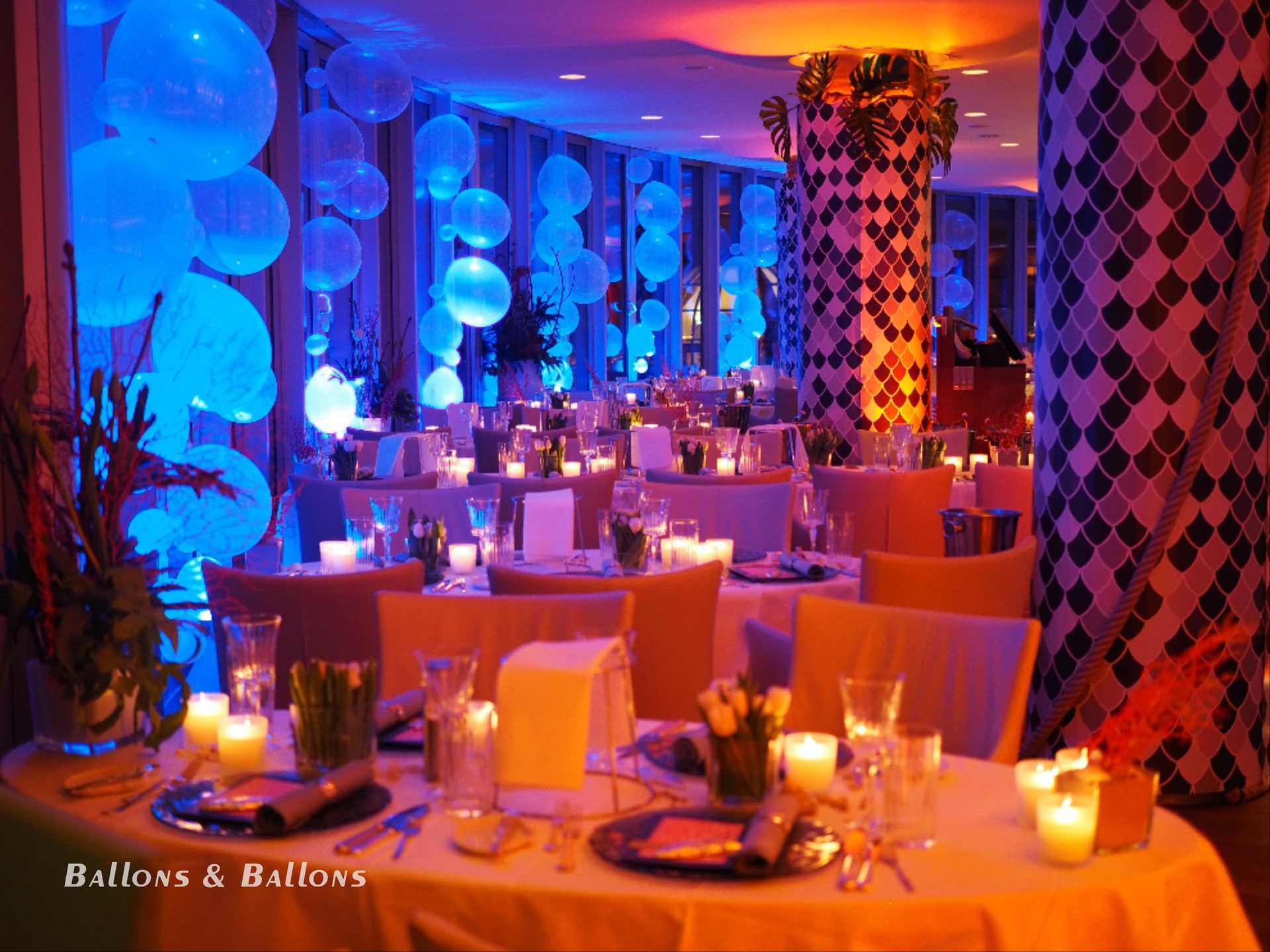 Ein Partyraum mit Ballons und Dekorationen in einem beleuchteten Restaurant in Wien.