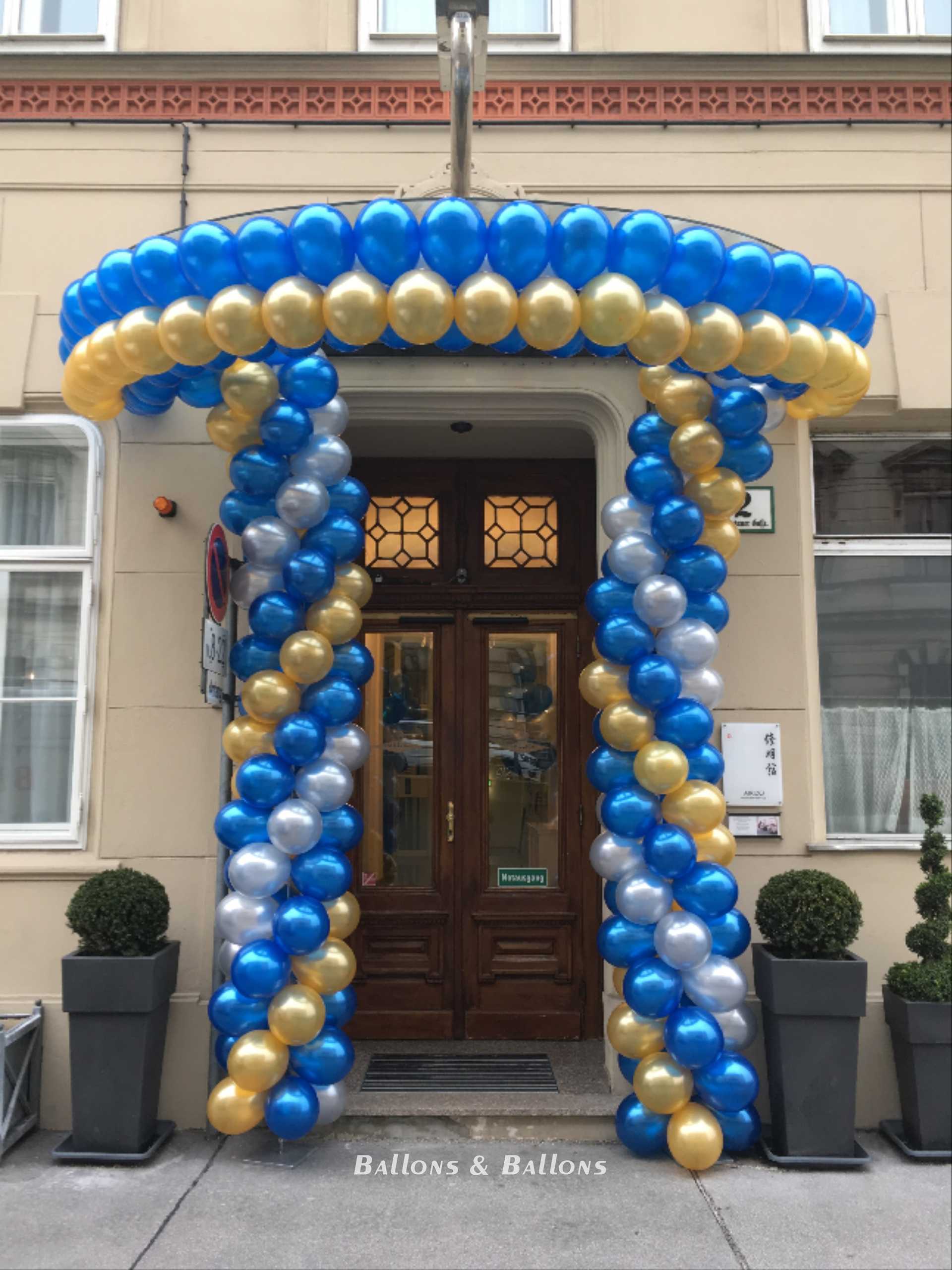 Eine Fronttür eines Hauses mit blauen und goldenen Ballons in Wien