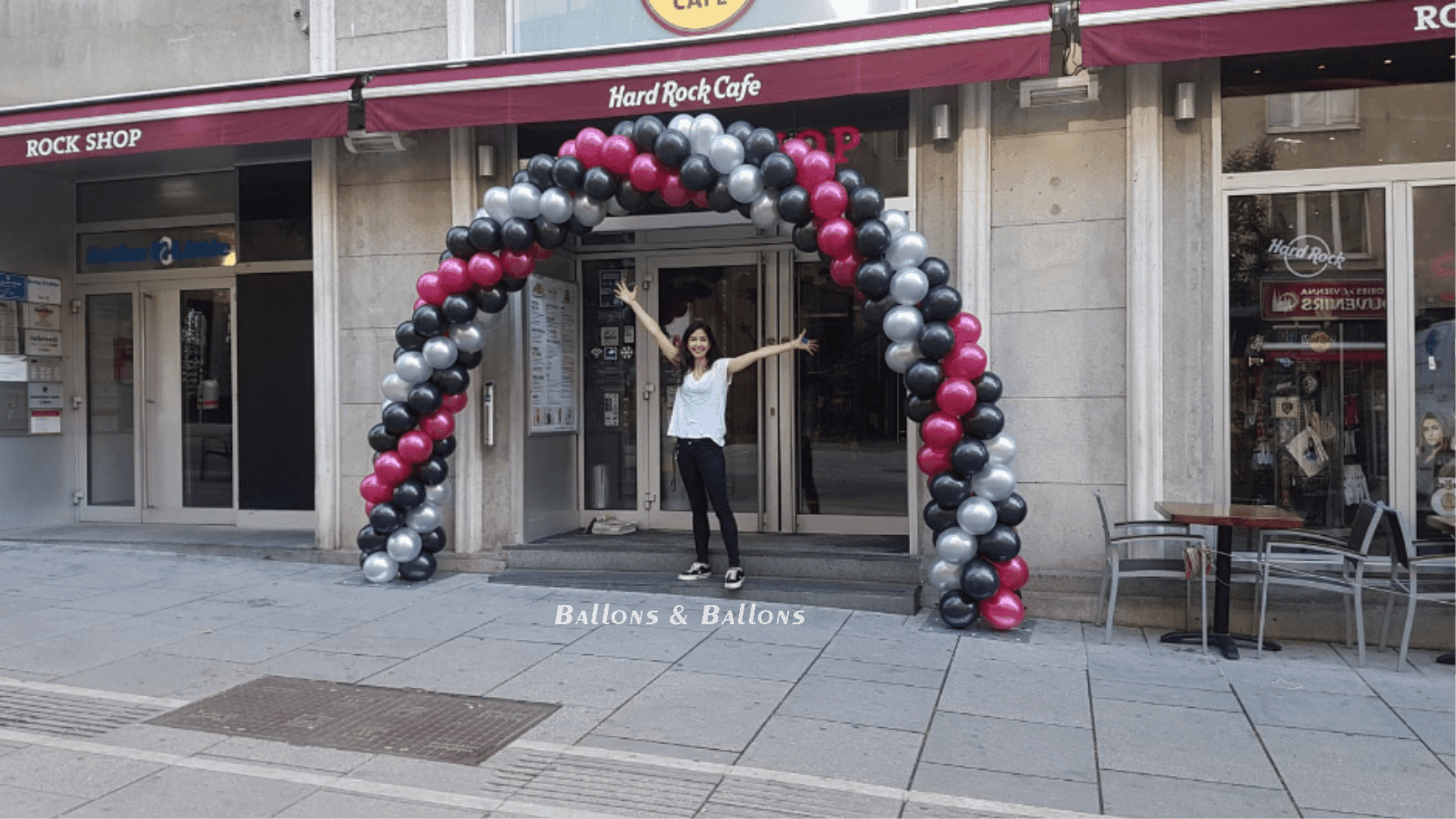 Eine Frau steht vor einem Geschäftseingang mit Ballons in Wien
