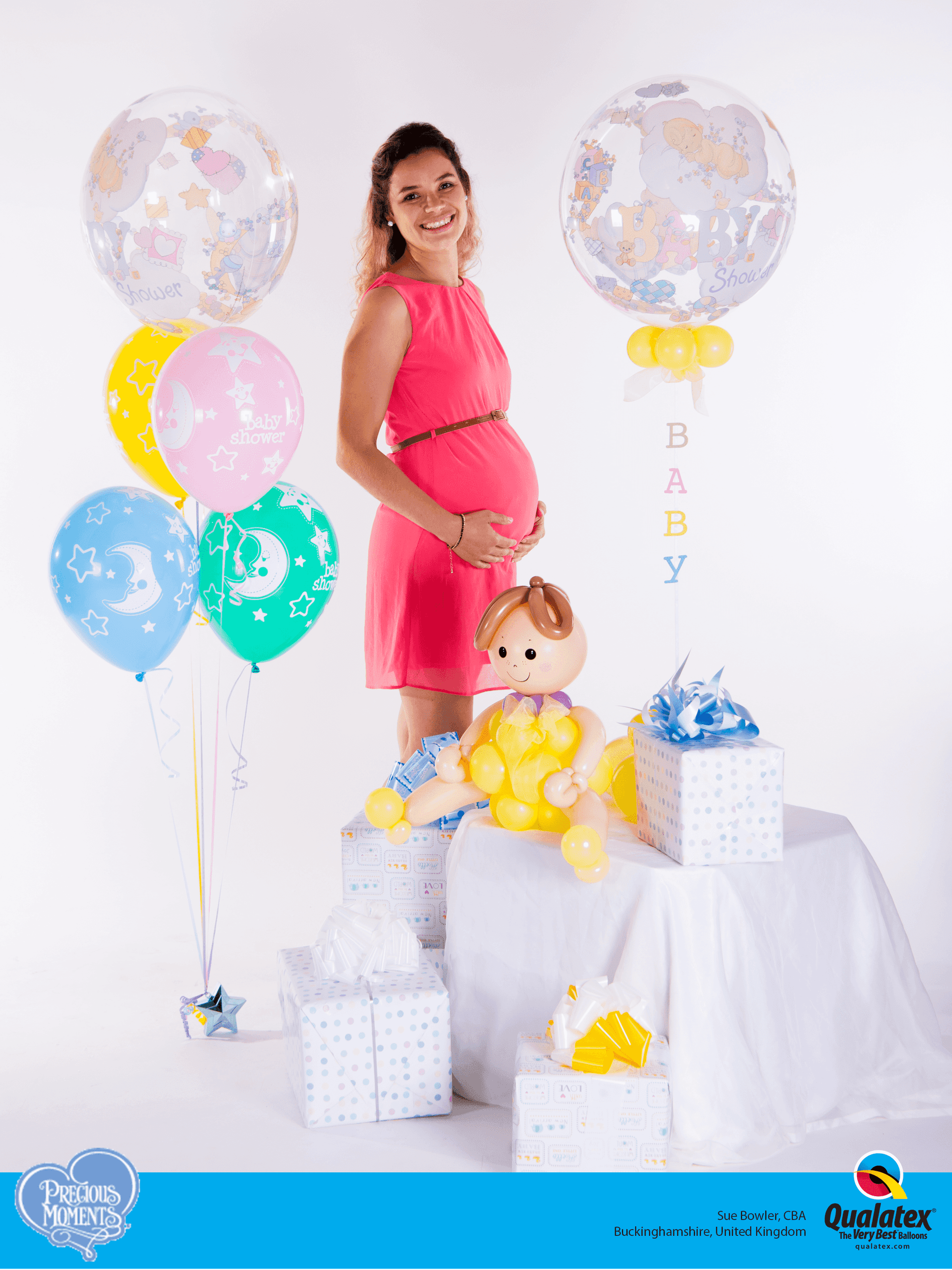 Eine schwangere Frau steht mit Ballons.