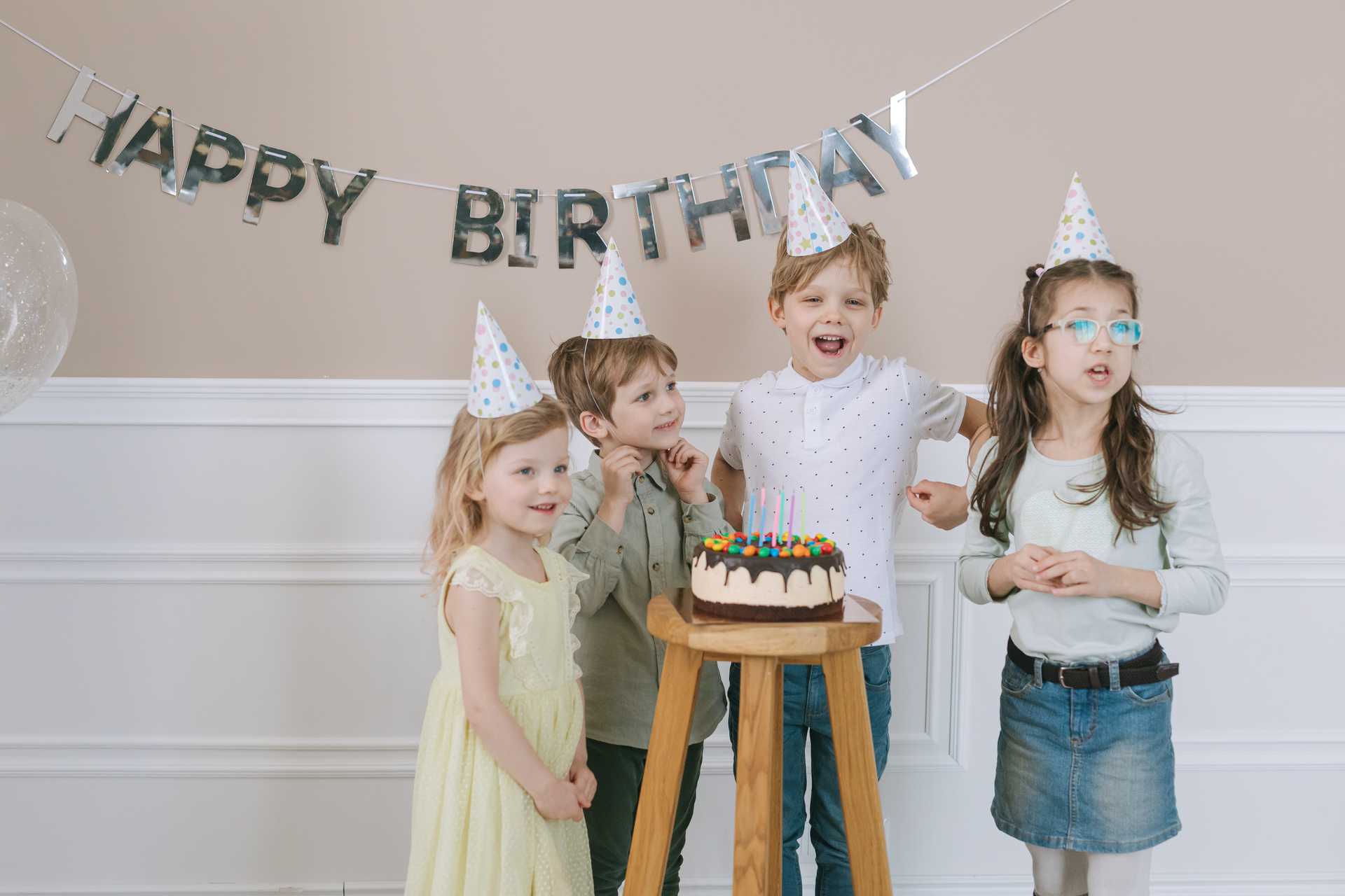 Eine Gruppe von Kindern vor einem Geburtstagskuchen.