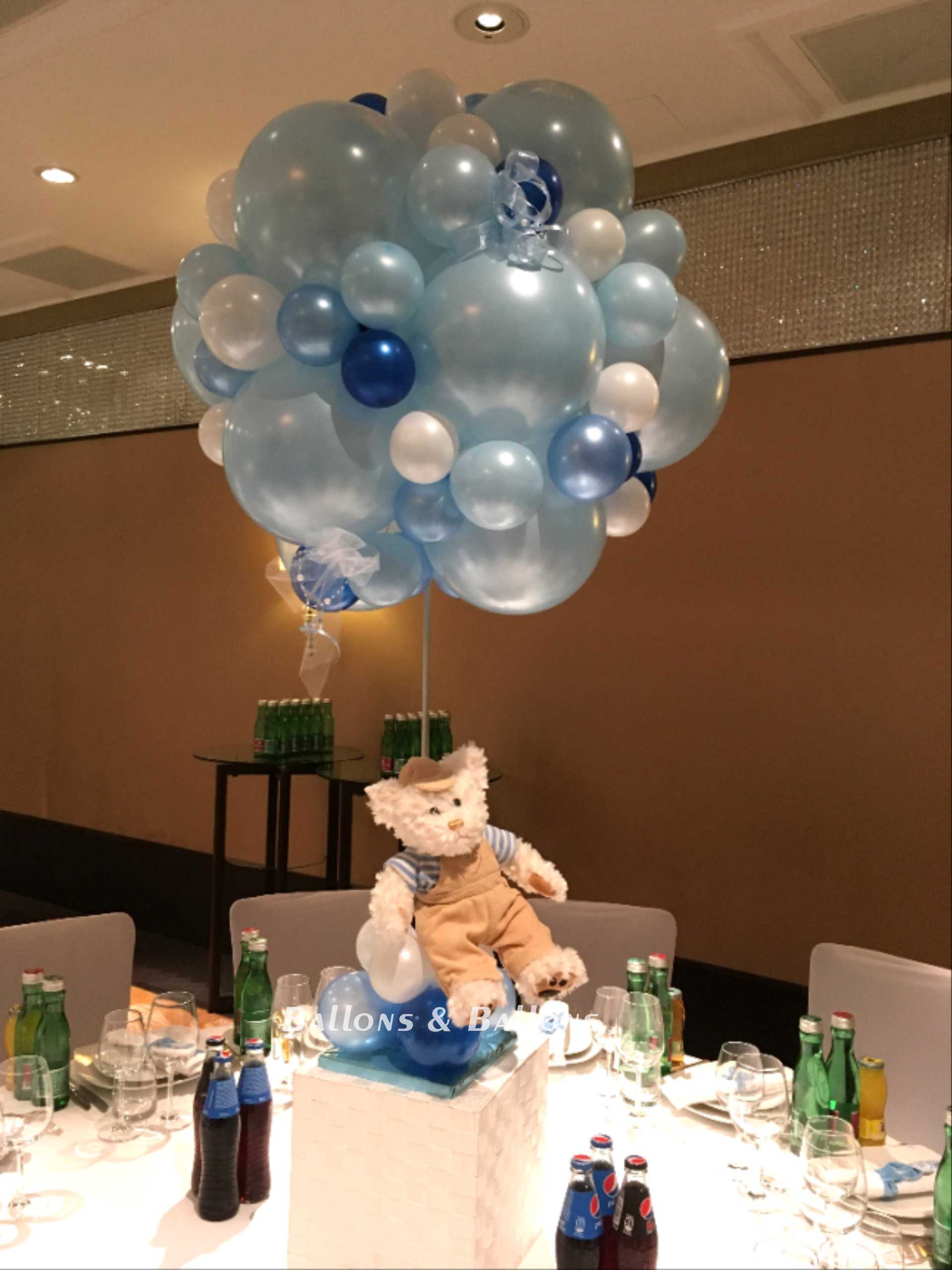 Ein Teddybär auf einem ballonbedeckten Tisch in Wien