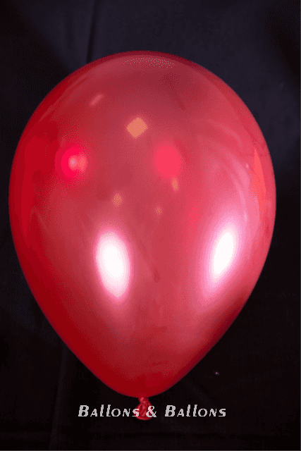 Eine Hand drückt einen roten Ballon an einen Gaskanister in Wien.