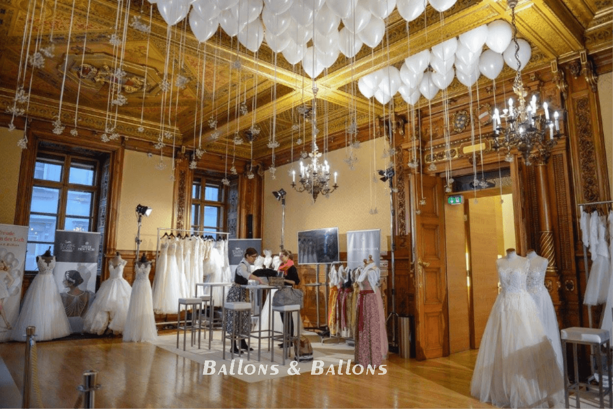 Viele Hochzeitskleider hängen an der Wand in einem Hochzeitssalon.