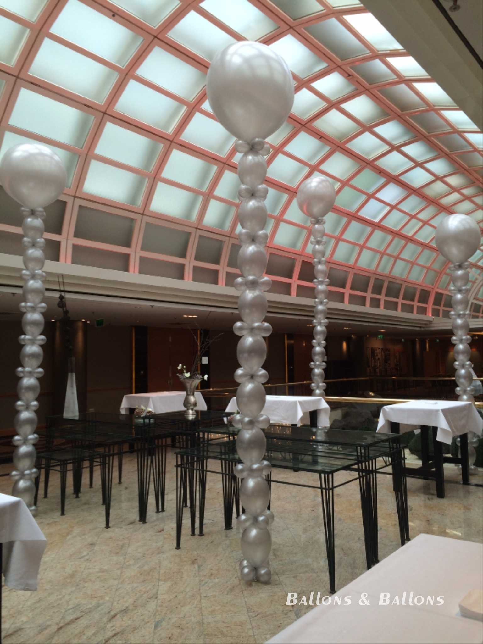 Ballons in einem Restaurantgang mit dekorierten Tischen in Wien.