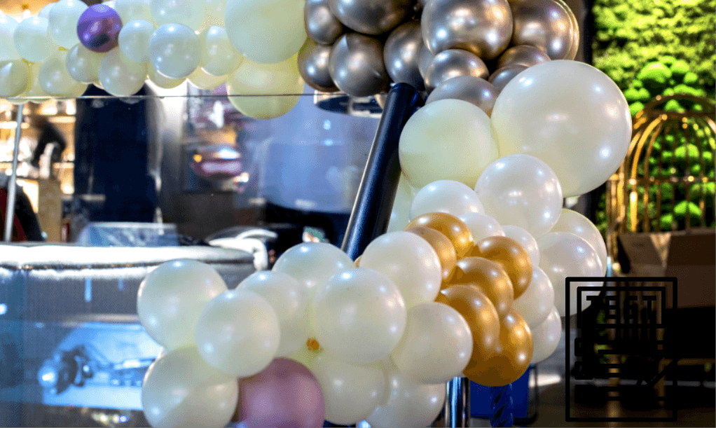 Ein Ballonbogen mit silbernen, goldenen und weißen Ballons in Wien.