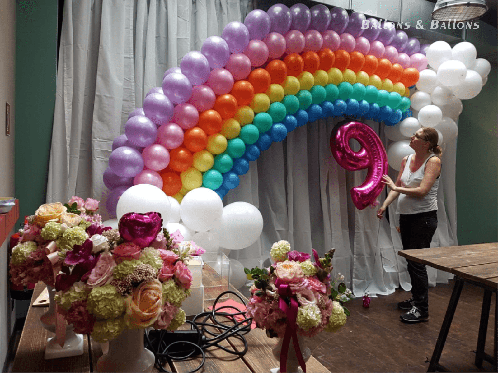 Frau arrangiert Ballondekorationen für eine Geburtstagsfeier in Wien